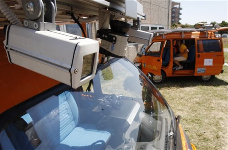 A video technician works on one of the unmanned, electric-powered orange vans that will leave Italy July 20, 2010, and are equipped with laser scanners and video cameras that work in concert to detect and help avoid obstacles. The vehicles will brave the traffic of Moscow, the intense summer heat of Siberia and the bitter cold of the Gobi desert before the planned arrival in Shanghai at the end of October.